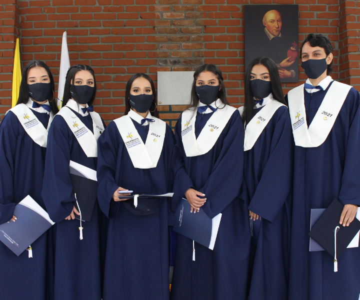 Seis estudiantes certificados con toga, ubicados en una fila. miran al frente.