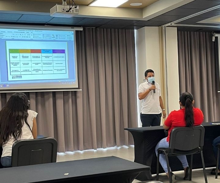 Grupo de personas en un salón recibiendo una charla