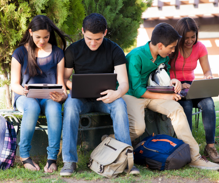 Estudiantes sentados en un parque