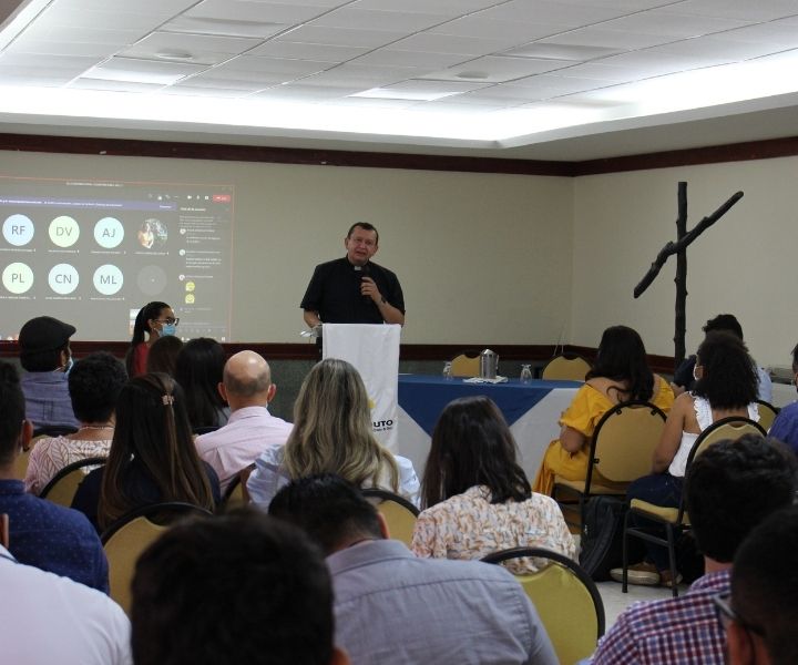 Un hombre dictando una conferencias a muchas personas 