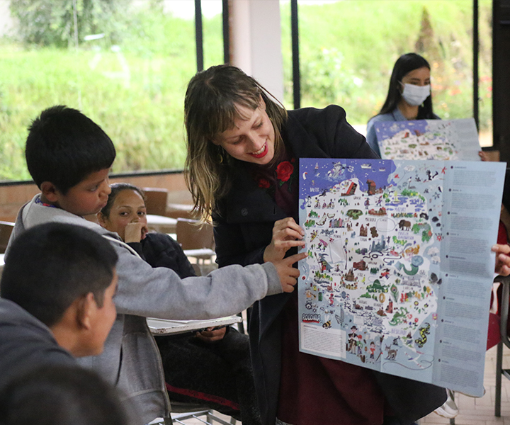 Sylwia  Wlodyga , voluntaria extranjera explica a los niños y niñas de la parroquia Jesús Obrero sobre la georreferenciación de Polonia. 