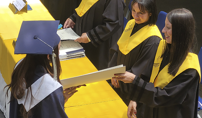 Estudiantes con toga y birrete dispuestos a recibir sus títulos profesionales de UNIMINUTO 