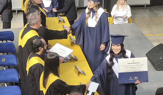 Estudiantes con toga y birrete dispuestos a recibir sus títulos profesionales de UNIMINUTO 