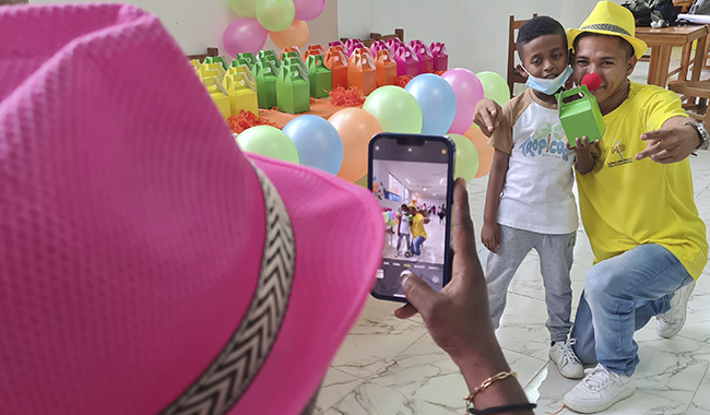 Docente tomándole fotografías a niños participantes de la feria lúdico pedagógica de UNIMINUTO en Urabá