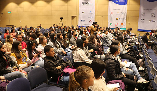 Estudiantes en auditorio escuchando conferencias  