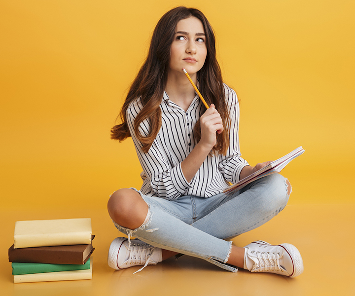 Chica con libros pensando qué escribir