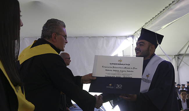 Graduado recibiendo su diploma UNIMINUTO 