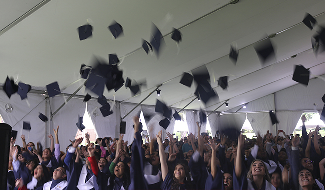 Graduados lanzando sus birretes en la ceremonia UNIMINUTO 