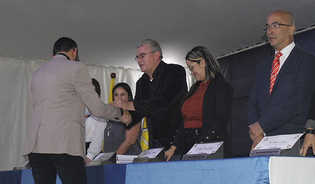 Estudiante recibiendo su certificado de beca UNIMINUTO