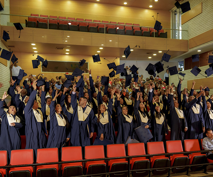 Graduandos lanzando el birrete 