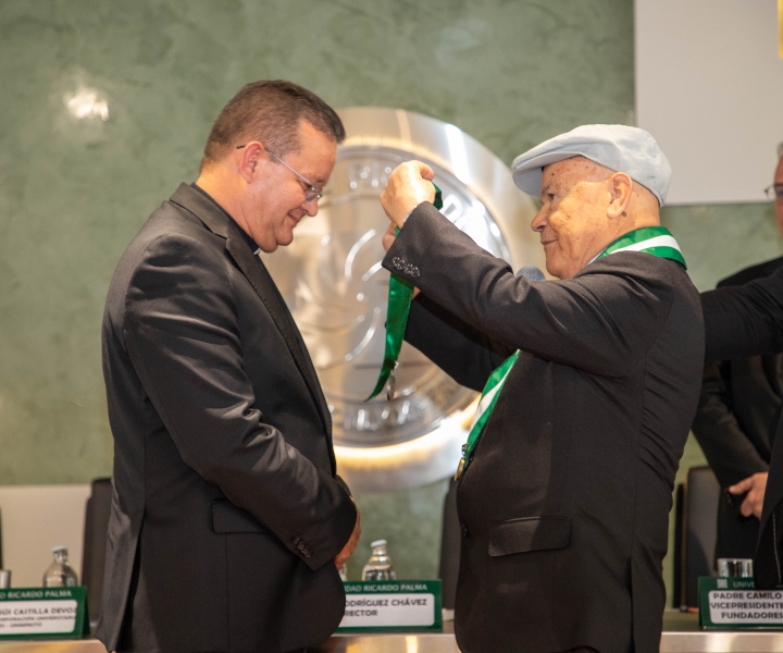 padre harold castilla recibiendo medalla