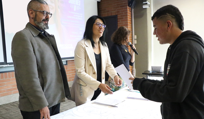 Estudiante recibiendo su certificación por parte de directivos UNIMINUTO 