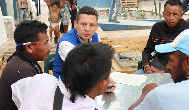 Colaborador de UNIMINUTO dialogando con las personas migrantes. 