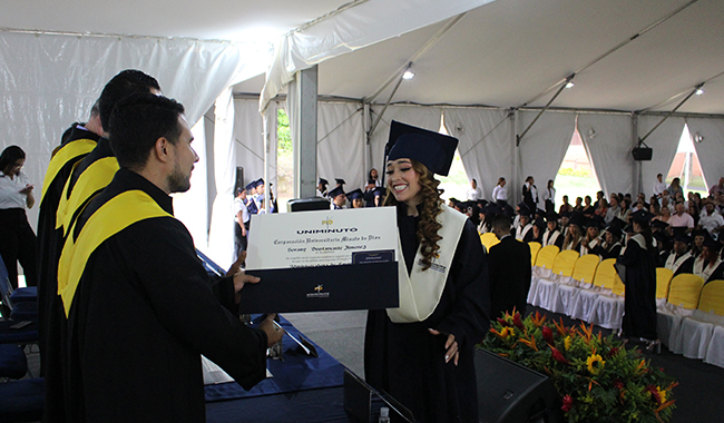 Estudiante recibiendo su diploma de carrera profesional en ceremonia. 