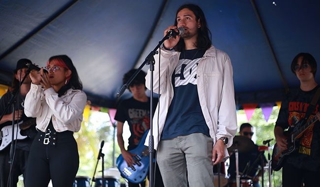 Estudiante de una de las instituciones de educación superior invitadas cantando en el escenario. 