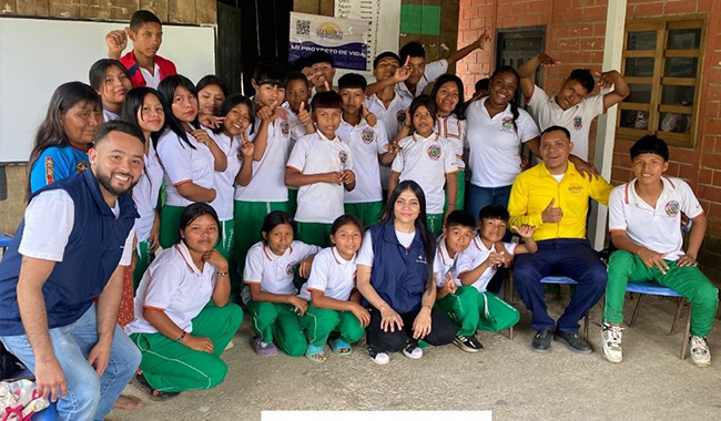 Estudiante de UNIMINUTO con la comunidad donde realizó su inmersión social.