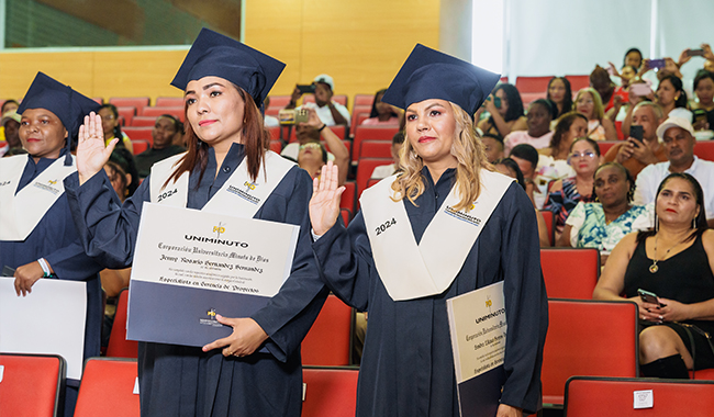 Graduandos haciendo su promesa profesional con la mano derecha arriba. 