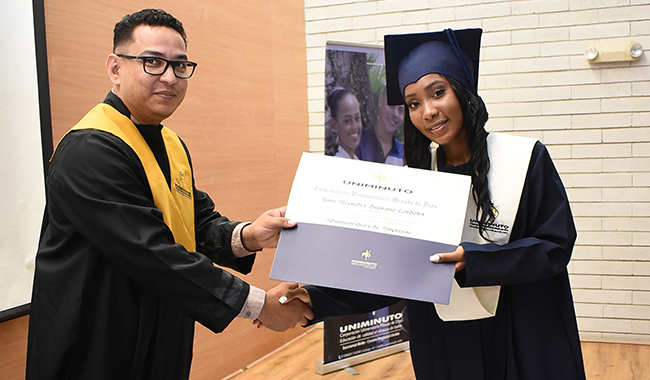 Graduanda recibiendo su diploma profesional. 