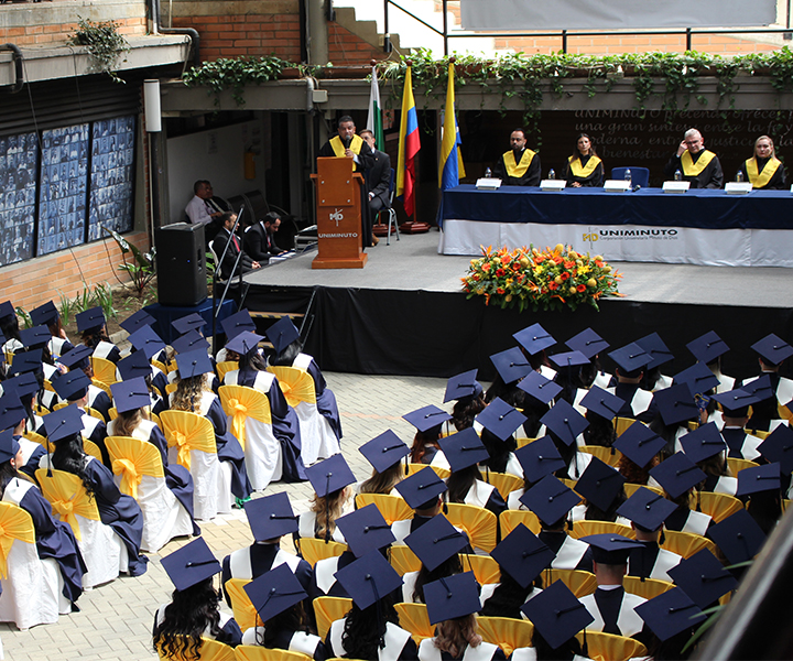 Graduandos con toga y birrete en ceremonia de graduación de UNIMINUTO seccional Antioquia - Chocó.