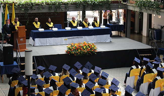 Graduandos con toga y birrete en ceremonia de graduación de UNIMINUTO seccional Antioquia - Chocó.