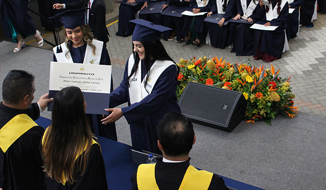 Graduandas recibiendo sus diplomas profesionales. 