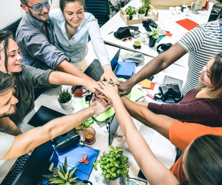 Nueve emprendedores juntando sus manos en señal de unión. 