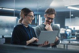 Hombre y mujer revisando computador