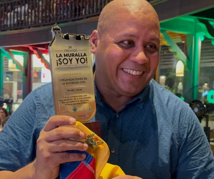 Docente con el reconocimiento en la mano 