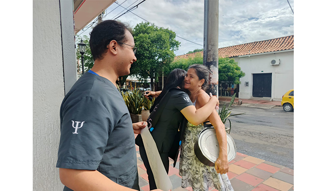 Un momento emotivo capturado durante la jornada de salud mental de UNIMINUTO Centro Universitario Cúcuta, donde una estudiante de Psicología abraza a una mujer como parte del "Stand de abrazos". 