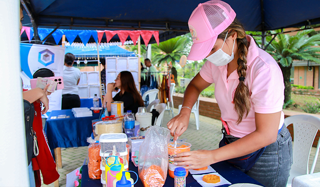Emprendora atendiendo su stand en la feria de UNIMINUTO