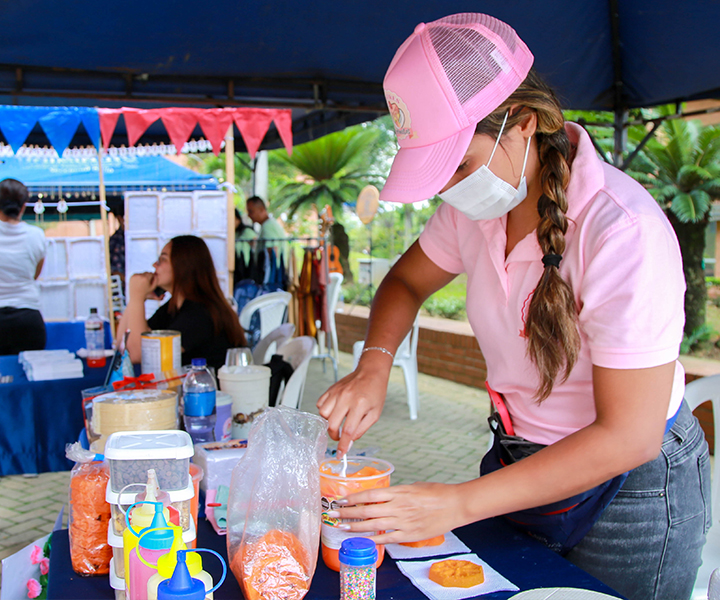 Emprendora atendiendo su stand en la feria de UNIMINUTO