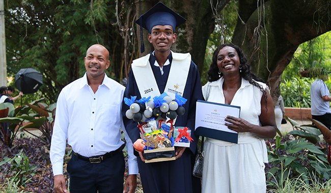 Estudiante certificado recibiendo un regalo de sus padres.