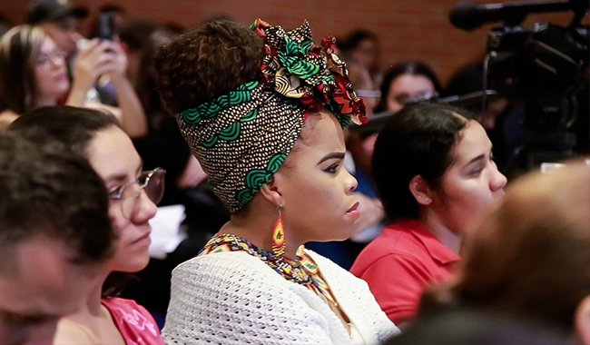 Asistente escuchando atenta las temáticas del encuentro por la paz de UNIMINUTO Seccional Antioquia - Chocó