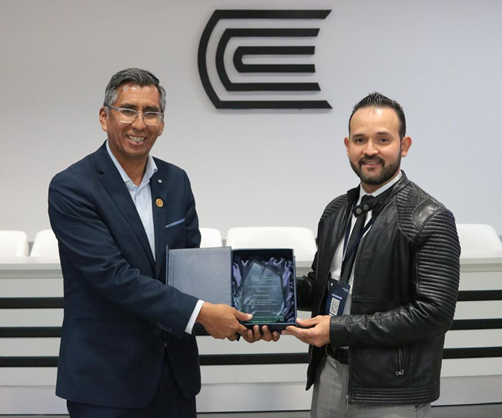 Decano de la Facultad de Ciencias Económicas y Administrativas UNIMINUTO recibiendo un reconocimiento.