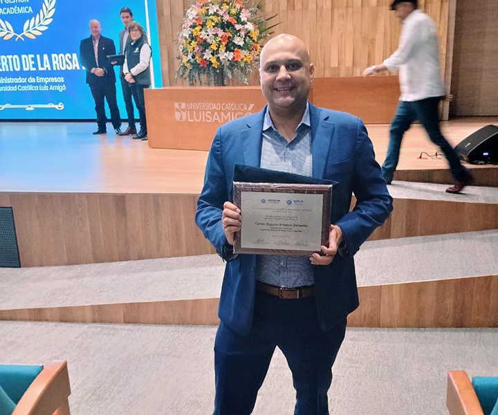 Egresado de UNIMINUTO recibiendo un reconocimiento de ASCOLFA. 