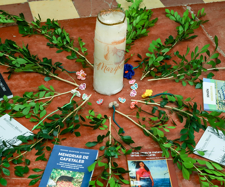 Ritual simbólico con vela, ramas y libros. 