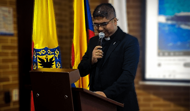Padre Danilo Manziller en atril dirigiéndose a lo asistentes 