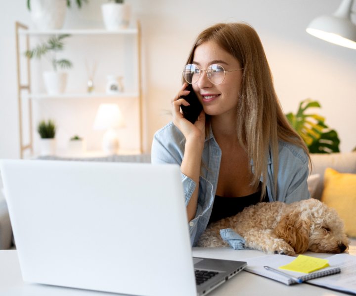 mujer hablando por celular acompañada de su mascota