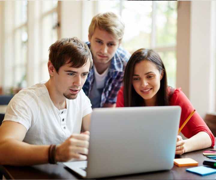 estudiantes observando pantalla de computador
