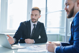 Hombres en mesa de trabajo revisando documentos