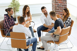 Grupo de jóvenes reunidos en mesa redonda 