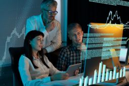 Tres personas mirando pantala digital