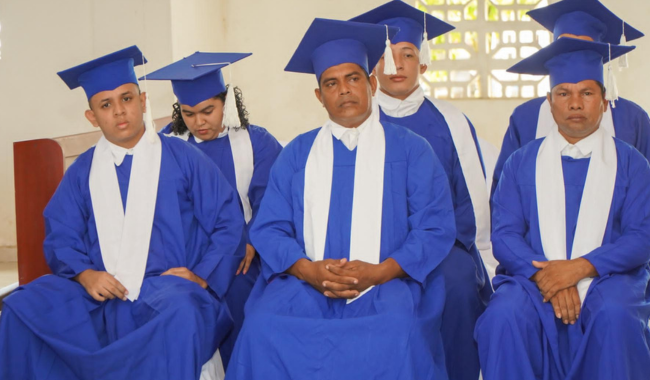 Graduados sentados escuchando 