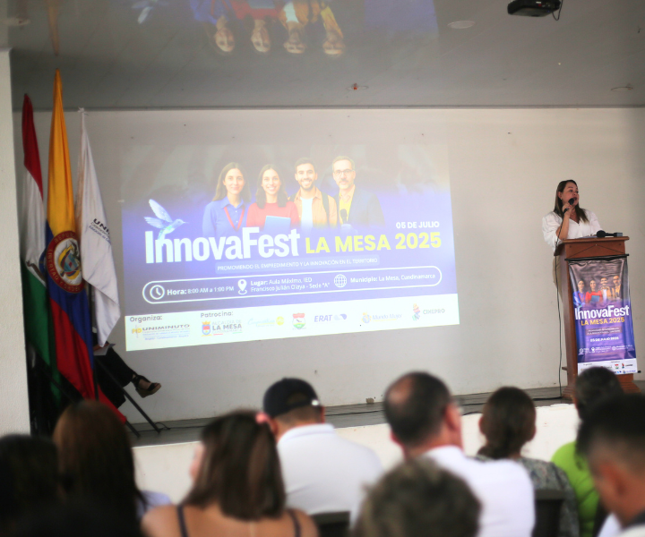 Coordinadora en tarima presentando programa