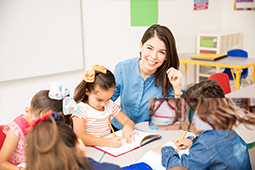 Profesora en mesa de trabajo con niños
