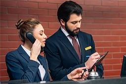 Dos personas en recepción de hotel revisando información