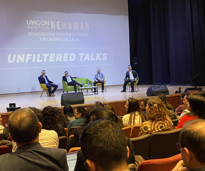 Cuatro ponentes en tarima dialogando frente al público asistente.