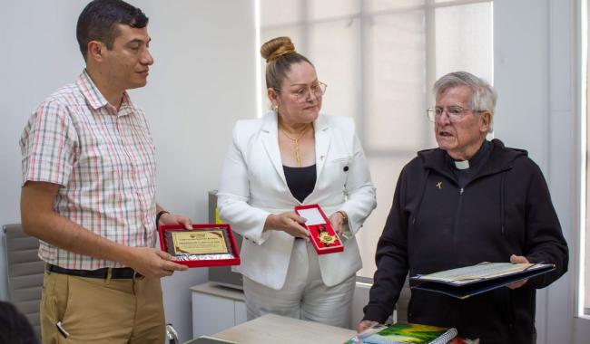 La presidenta del Concejo Municipal de Cúcuta, Carime Rodríguez, entrega al Padre Diego Jaramillo la condecoración Gran Cruz del Norte
