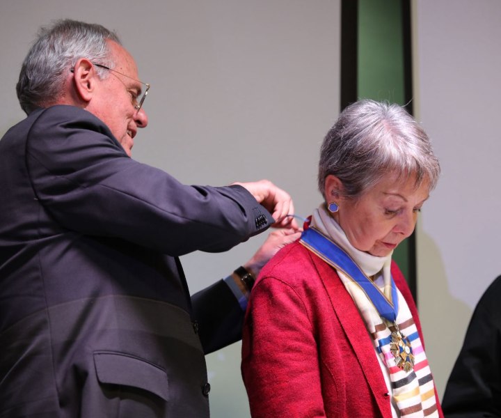 Foto del padre Camilo Bernal entregando la condecoración a la doctora Sara Ordóñez Noriega