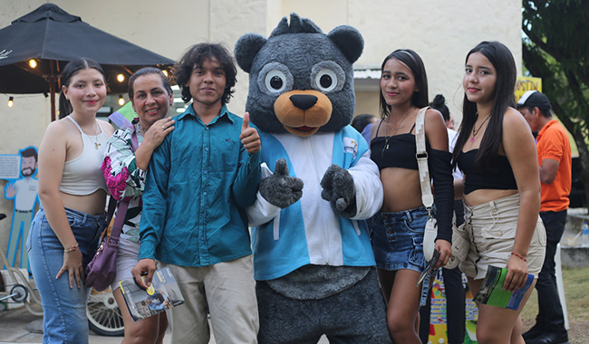 Estudiantes abrazados con Minu, mascota oso